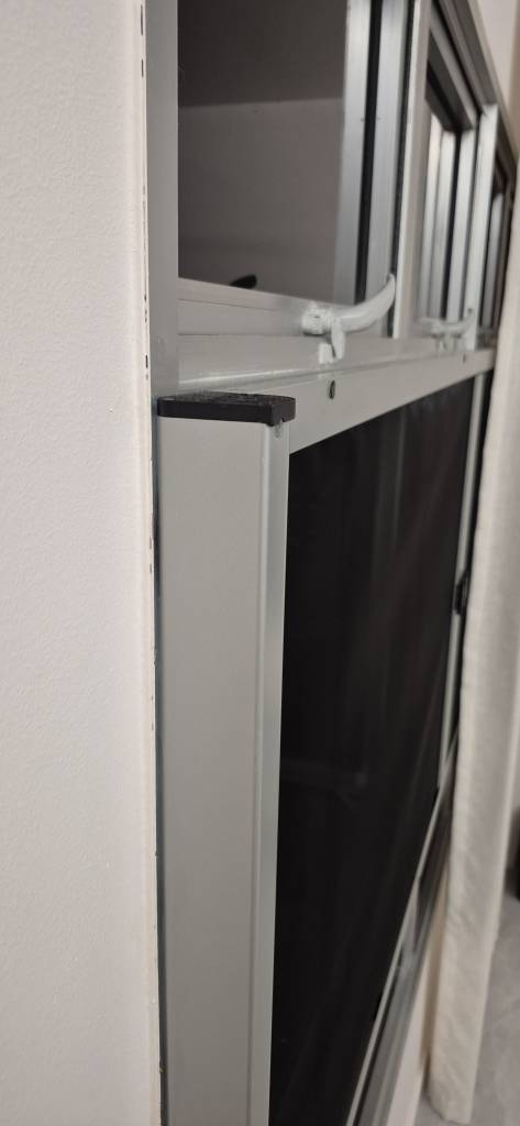 Side-profile view of the sleek retractable mesh housing integrated into a window frame.