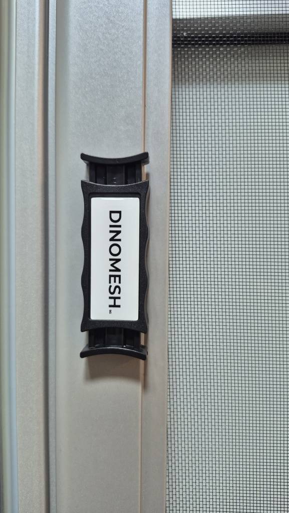 Close-up of the Dinomesh brand handle on a fine retractable insect mesh.