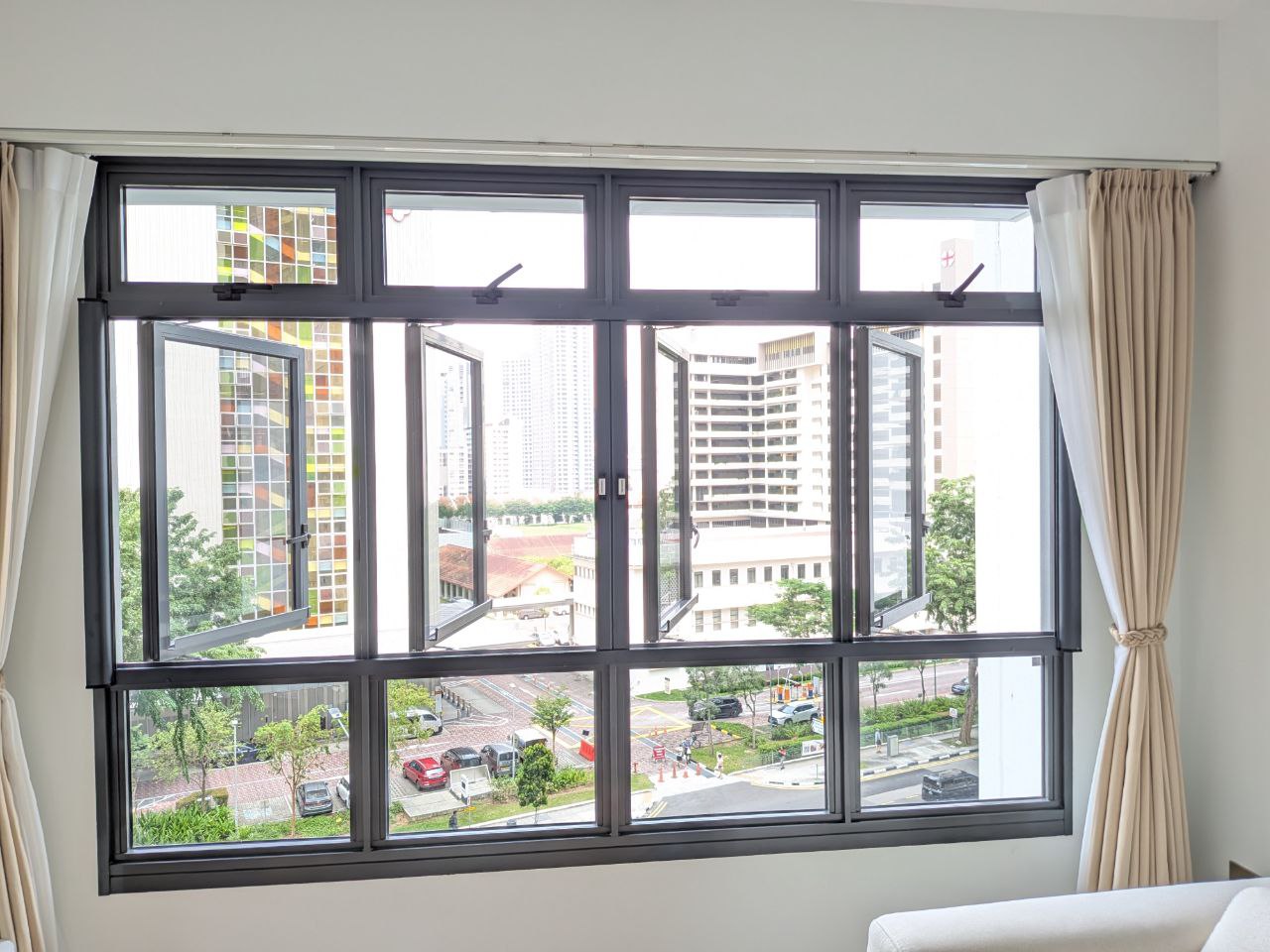 Dinomesh retractable mesh on a wide living room window overlooking a garden.